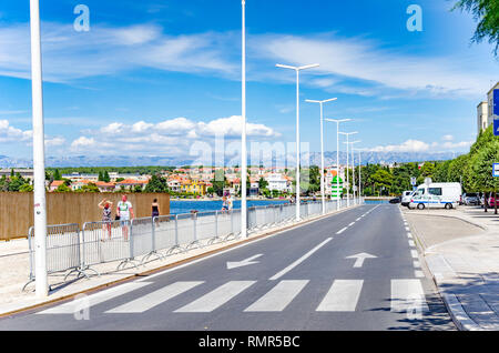 Adria Damm mit einem Leuchtturm und Touristen im Sommer in Zadar, Kroatien. Stockfoto