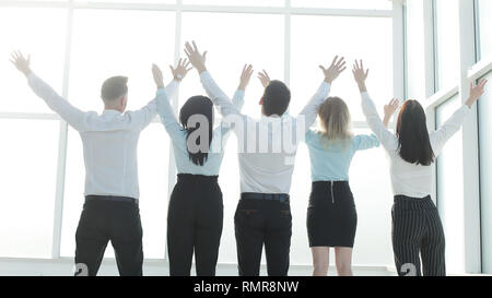 Ansicht der Rückseite. Business Team mit hands up Stand vor der Office Fenster Stockfoto