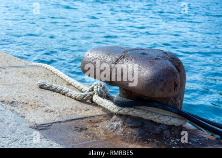 Altes Eisen Liegeplatz Poller mit schwarzen und weißen Seile Stockfoto