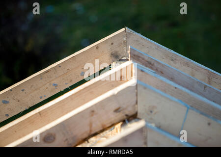 Close-up Detail der Dachrahmen aus grobem Holz Bauholz Balken auf dem Hintergrund von Misty Mountain Landschaft im ökologischen Bereich. Gebäude, Dach, constructi Stockfoto