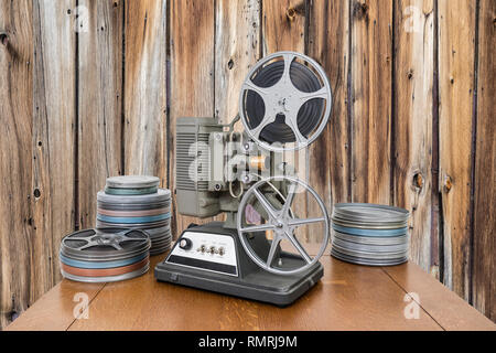 Vintage 8-mm-Film Projektor und Film Dosen mit altem Holz Wand. Stockfoto