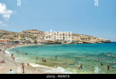 Touristen schwimmen am Strand von Matala, Insel Kreta, Griechenland, 22. Juni 2018 Stockfoto