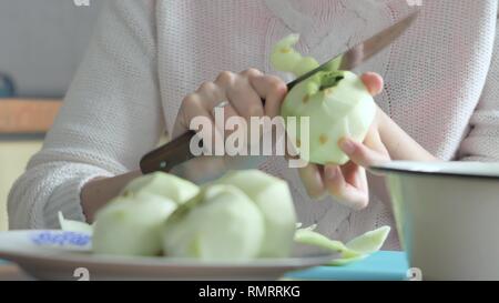 Eine Frau, die eine Apple auf einer Platte Frau der Tabelle löscht geschält. bereitet Brot oder Apfelkuchen Stockfoto