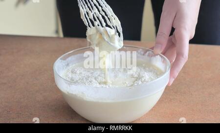 Sahne Eigelb mit Zucker in eine Glasschüssel Eischnee gemischt mit Eigelb und Sahne Mehl hinzugefügt wird Stockfoto