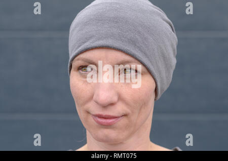 Portrait von lächelnden Frau mittleren Alters tragen graue Mütze Hut, uns auf die Seite. Stockfoto
