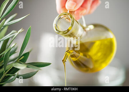 Flasche natives Olivenöl aus der Nähe gießen Stockfoto