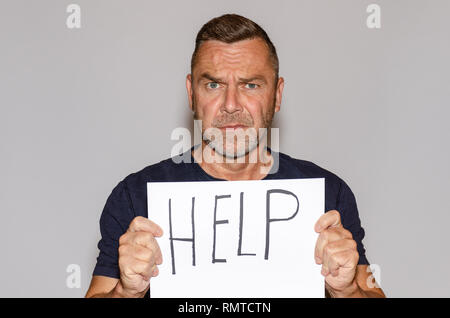 Im mittleren Alter Mann mit weissen Blatt Papier mit Hilfe Schriftzug Stockfoto