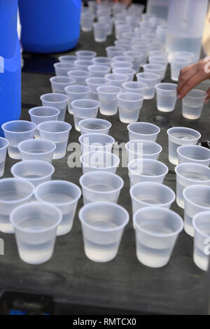 Disposeable aus Kunststoff Tassen auf dem Tisch für das Trinken an einer Straße Rennen. Kunststoff Recycling Stockfoto