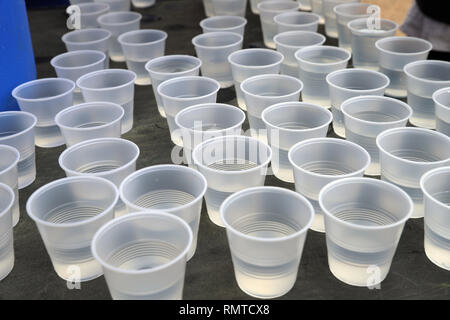 Disposeable aus Kunststoff Tassen auf dem Tisch für das Trinken an einer Straße Rennen. Kunststoff Recycling Stockfoto