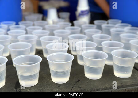 Disposeable aus Kunststoff Tassen auf dem Tisch für das Trinken an einer Straße Rennen. Kunststoff Recycling Stockfoto