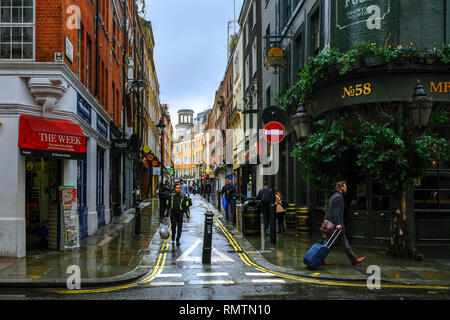 London, Großbritannien - 12 März 2018: Menschen zu Fuß auf der Straße in Covent Garden, an einem regnerischen Tag in London. Stockfoto