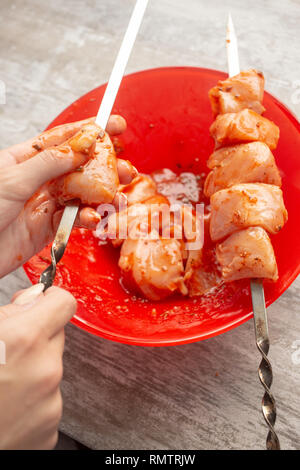 Weibliche Hände Spieß gebeizt Fleisch am Spieß Stücke Stockfoto