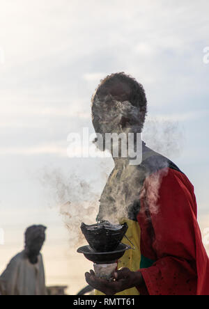 Mann mit Insence brennen Während der Freitag sufi Feier an der Sheikh Hamad el Nil Grab, Khartum, Omdurman, Sudan Stockfoto