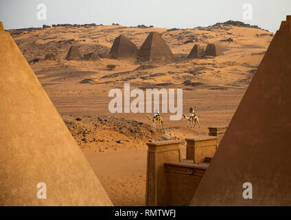 Sudanesische Männer und ihre Kamele vor den Pyramiden von Meroe, kushite Herrscher im nördlichen Staat, Meroe, Sudan Stockfoto