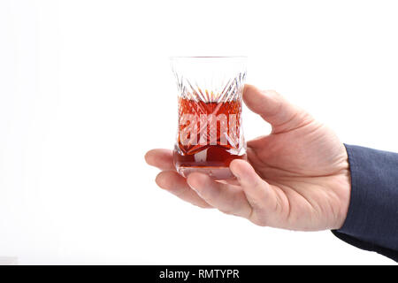 Glas türkischen armud mit Tee in männlicher Hand auf einem weißen Hintergrund. Close Up. Platz kopieren Stockfoto