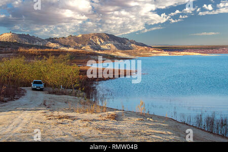 Malerische Landschaft Szene der ein Auto über einen See gegen Berge geparkt. Stockfoto