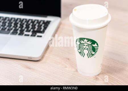Starbucks Kaffeetasse auf dem Schreibtisch im Büro neben Computer Laptop. Slowenien 13.02.2019 Stockfoto