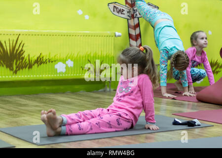 Kinder Yoga im Schlafanzug mit einem professionellen Lehrer. Stockfoto