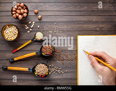 Holzlöffel, mit floralen Ornament im Stil von Khokhloma russischen Holz Kunst mit Müsli und die Mutter auf den Tisch gemalt. Platz für Ihren Text in die no Stockfoto