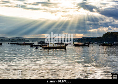 Der morgen Sonnenstrahlen, die durch die Wolken, die Boote in Zemun Quay an Donau geparkt beleuchten. Stockfoto