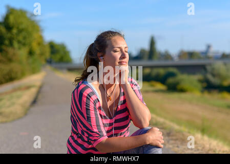 Schöne Frau hört Musik durch Ihre Kopfhörer und genießt den Moment Stockfoto