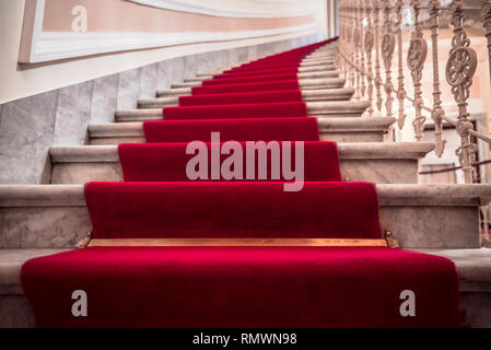 Luxuriöse Gebäude Interieur mit der Marmor Treppe mit rotem Teppich bedeckt Stockfoto