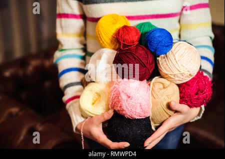 Junge hübsche Frau mit vielen bunten Garnen clews. Stockfoto