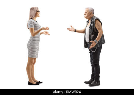Volle Länge Profil Schuß einer jungen Frau im Gespräch mit einem verärgerten männlichen Punker in einem Leder weste auf weißem Hintergrund Stockfoto