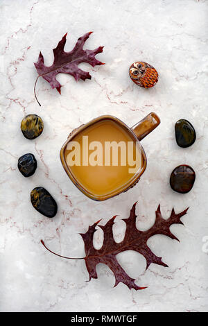 Kaffee und getrocknete Eichenblätter mit polierten Steinen und gemalten Eule rock Still life auf Marmor Hintergrund. Vertikales format in Flach Komposition. Stockfoto