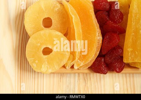 Getrocknete Stücke von Papaya, Mango, Ananas und Erdbeere Früchte, der lag auf einem Bambus Platte auf einem Holztisch. Makro. Nahaufnahme Stockfoto