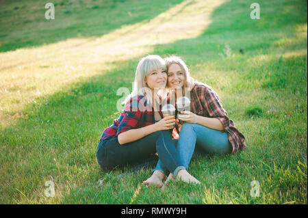 Junge Freundinnen umarmten im Sommer Park. Stockfoto