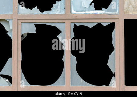 Alte Fenster mit zerbrochenen Glasscheiben undurchsichtig weißes Glas mit gezackten Kanten in der Nähe zu sehen. Stockfoto