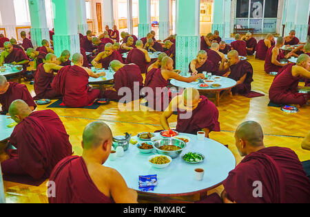 BAGO, MYANMAR - Februar 15, 2018: Das Mittagessen im Speisesaal des Kha Khat Waing Kyaung Kloster, zahlreiche bhikkhu Mönche Reis mit Gemüse essen, ein Stockfoto