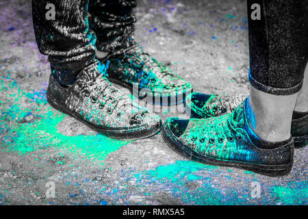 Schwarz Laufschuhe in bunten Pulver Farbe bedeckt Stockfoto