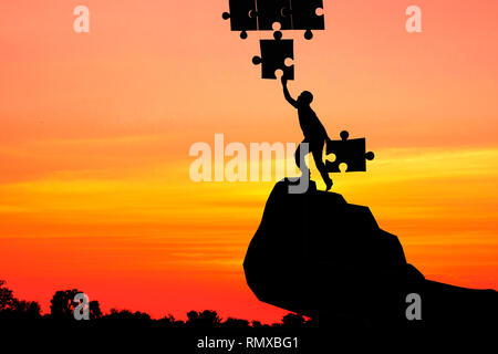 Silhouette Menschen jigsaw setzen mit einem anderen auf Sky Stockfoto