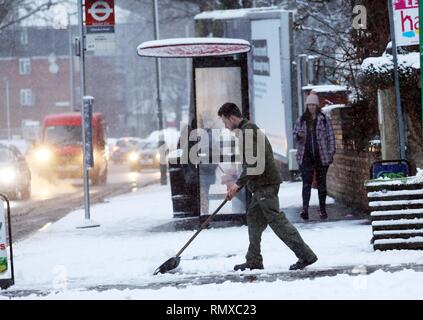 Bild zeigt: Schnee und Schneeregen behindert Pendler auf ihre Arbeit heute im East Finchley, London Clearing bis außerhalb seines Flower Shop pic von Gavin Stockfoto