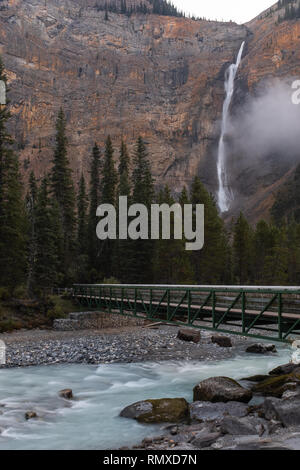 Ein grosser Wasserfall drop mit einer Brücke und Fluss im Vordergrund Schuß auf langsamen Verschlusszeit mit einem ​Portrait Aspekt Stockfoto