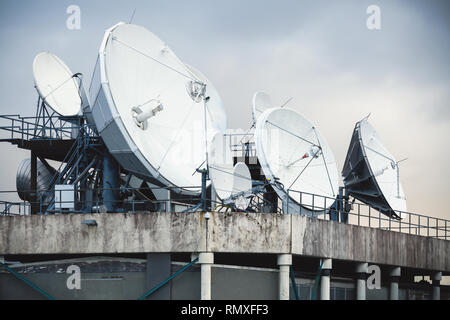 Parabolantenne auf dem Dach eines Industriegebäudes montiert Stockfoto