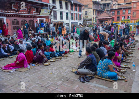 GOLDEN TEMPLE, Kathmandu, Nepal - ca. 2013: Nepalesische warten für religiöse Mahlzeit von einem lokalen Hindu Tempel in Kathmandu, Nepal angeboten Stockfoto