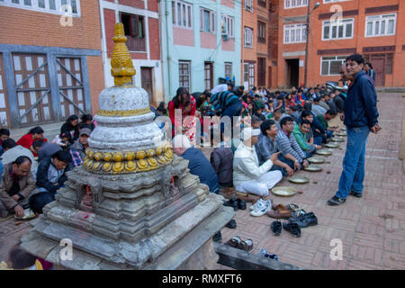 GOLDEN TEMPLE, Kathmandu, Nepal - ca. 2013: Nepalesische warten für religiöse Mahlzeit von einem lokalen Hindu Tempel in Kathmandu, Nepal angeboten Stockfoto