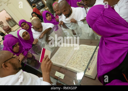 MEDINA, Saudi-arabien - ca. 2016: Eine Gruppe von muslimischen Pilger aus Indien hören Sie Ihren Führer erklärt die frühe Version des Koran in einem Museum. Stockfoto