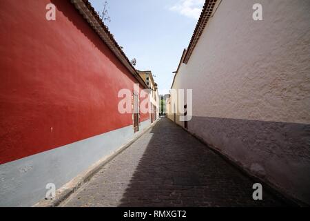 Einen engen Durchgang zwischen roten und weißen Wänden. Lange und schmale Straße mit farbigen Wänden. Wide Angle Shot Straße nach La Laguna, Teneriffa. Stockfoto