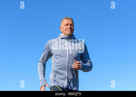 Vorderansicht des grauen lächelnden Mann, Sportswear entlang des Flusses in einer niedrigen Winkel anzeigen Stockfoto