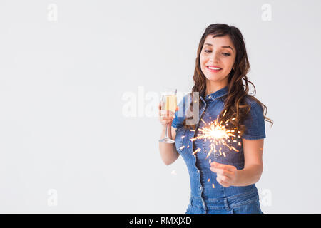 Leute, Feiern und Urlaub Konzept - schöne Frau mit Wunderkerzen und Glas Champagner über weißen Hintergrund mit Kopie Raum Stockfoto