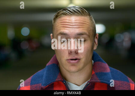 Eine junge, stilvoll, u-Mann auf der Suche nach unten in einem städtischen Portrait. Stockfoto