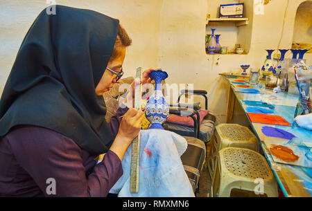 ISFAHAN, IRAN - Oktober 21, 2017: Der junge Handwerker ein Muster auf graviert Vase in traditionellen alten meenakari Emaille Technik erstellen, am 21. Oktober in Stockfoto