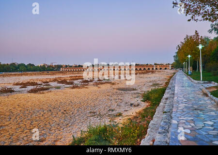 Die abendlichen Spaziergang im Stadtpark entlang der Ufer des ausgetrockneten Zayandeh River mit Blick auf Siosepol (Allahverdi Khan) bogenförmige Brücke, Isfahan, Iran. Stockfoto