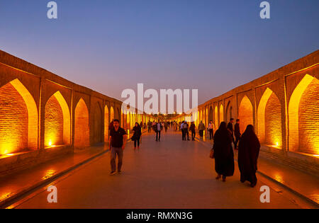 ISFAHAN, IRAN - 21. OKTOBER 2017: Spaziergang entlang der abendlichen Fußgängerzone (Siosepol Allahverdi Khan) Brücke mit beleuchteter Stein Nischen auf beiden Seiten, auf Stockfoto