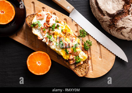 Essen Konzept organische französische Sauerteig mit Eiern und Schinken auf Holz Schneidebrett getoastet Stockfoto