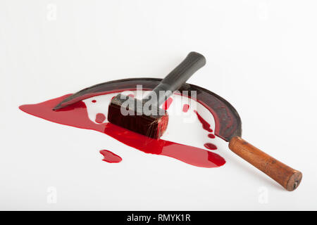 Hammer und Sichel mit Blut verschmiert, auf einem weißen Hintergrund. Visuelle Beschreibung eines totalitären Staates. Stockfoto